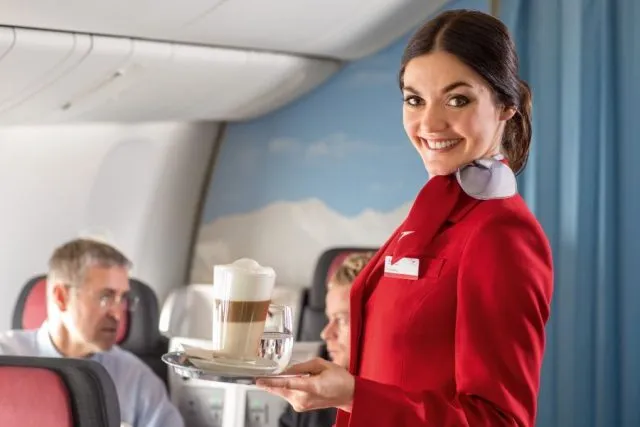 An_Austrian_Airlines_flight_attendant_serving_refreshments_to_passengers