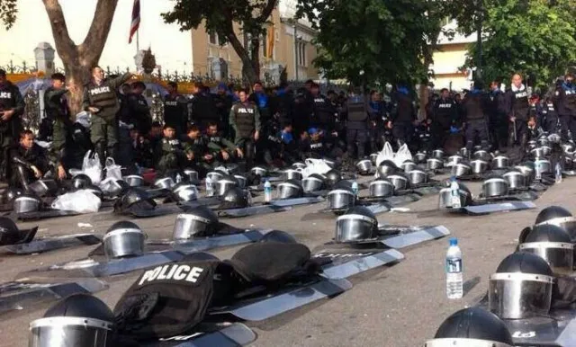 Thai-police-lay-down-shields-and-helmets-join-people