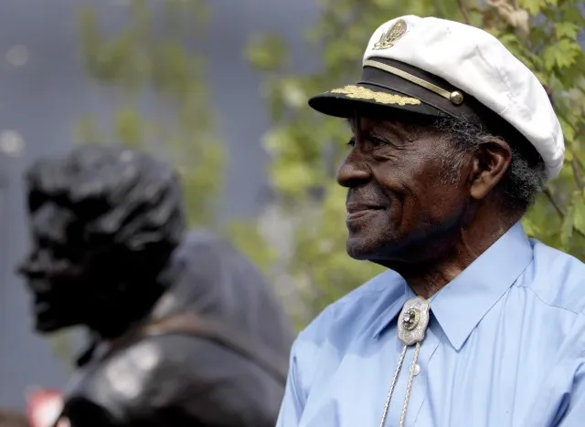 Legendary musician Chuck Berry sits on a stage next to a statue of himself during its dedication Friday, July 29, 2011, in University City, Mo. The statue of the St. Louis native was dedicated near Blueberry Hill, the University City club where the octogenarian still performs monthly. (AP Photo/Jeff Roberson)